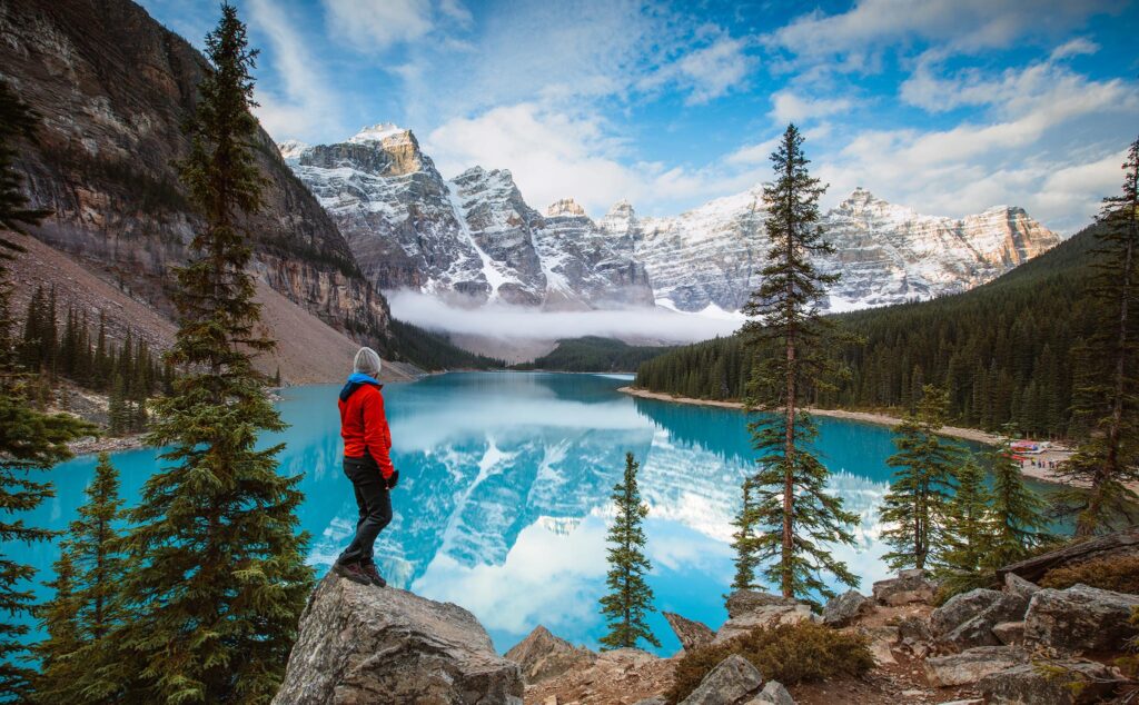 Mann betrachtet den Moraine Lake bei Sonnenaufgang, Banff National Park, Alberta, Kanada