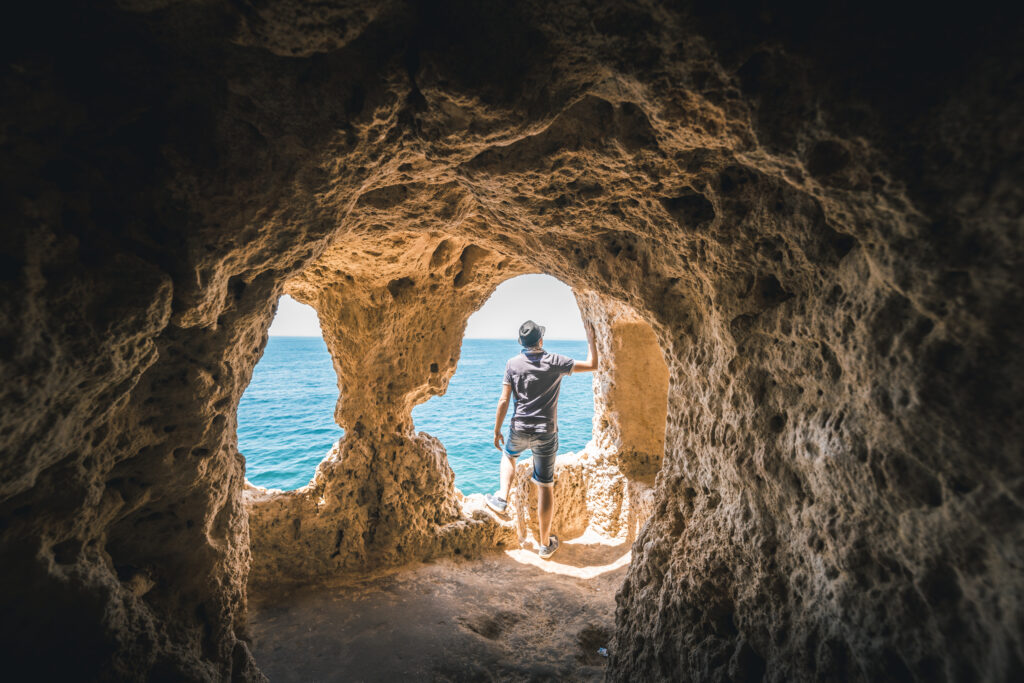 Man exploring the Algar Seco rock formation, Portugal