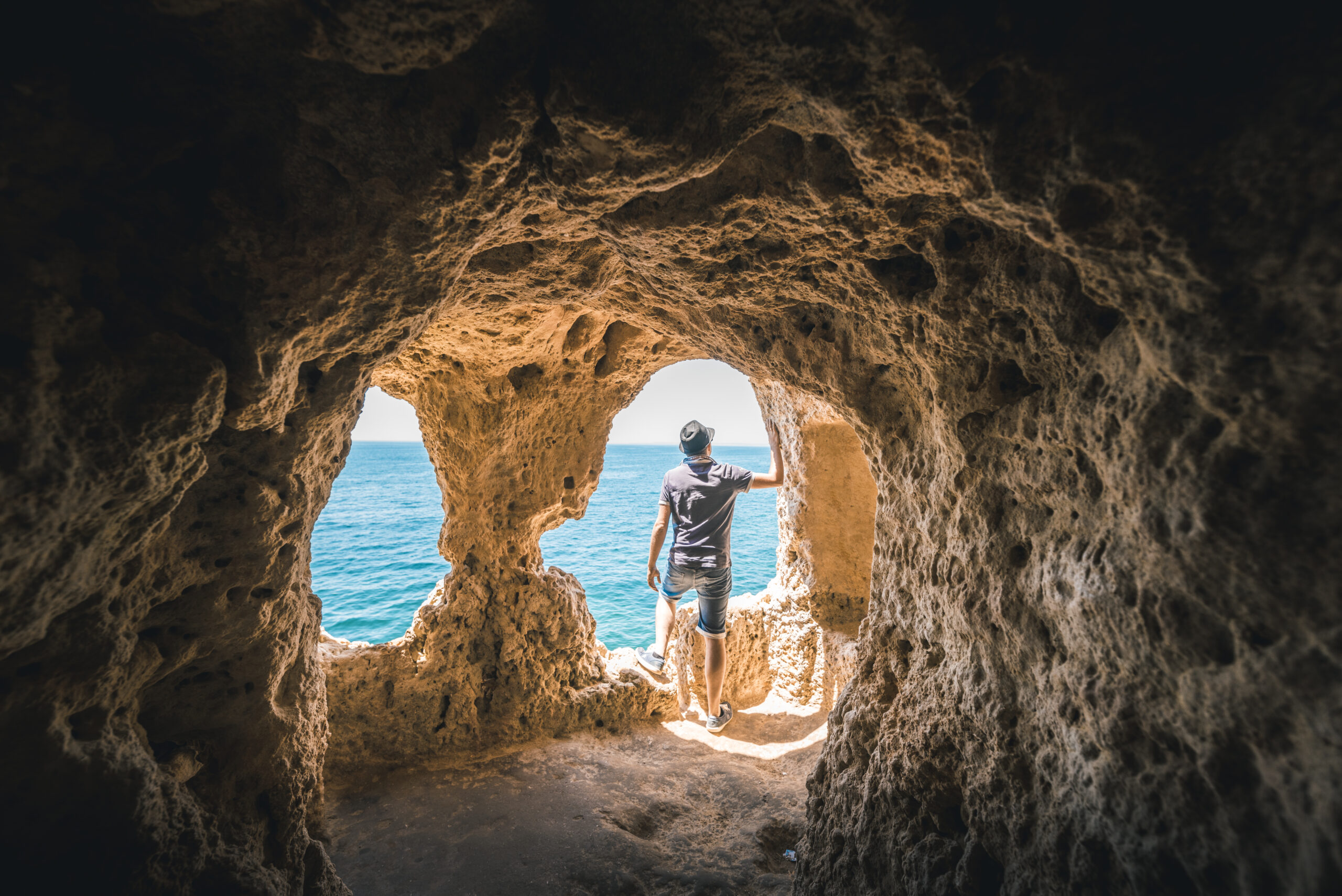 Man exploring the Algar Seco rock formation, Portugal